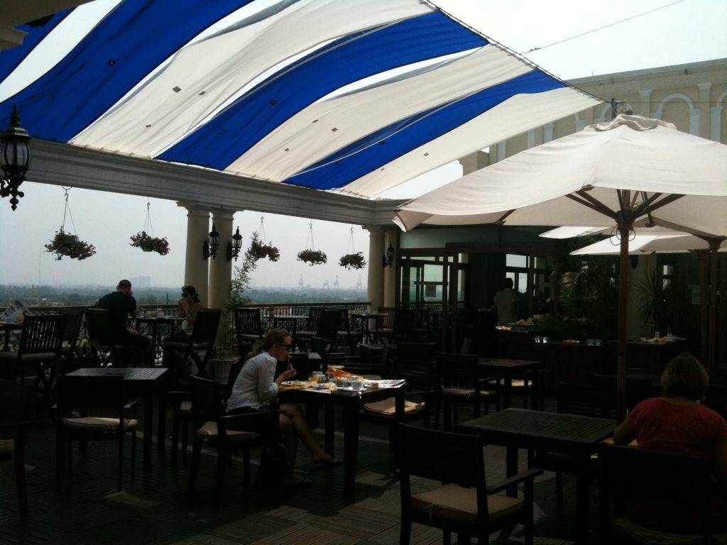 호치민 1군 술집 중 사이공강 쪽 호텔 옥상 바의 테이블과 차양