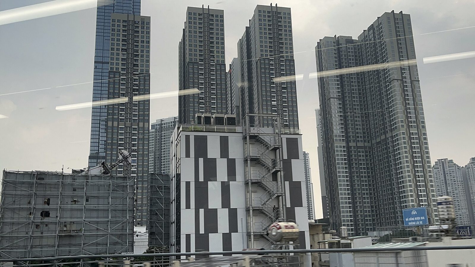 호치민 숙소 위치 비교 지하철 1호선 차창 밖 강변 고층 단지